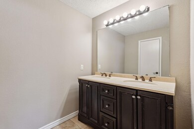 Full bath with a textured ceiling, double vanity, 
