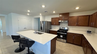 Kitchen featuring stainless steel appliances, a breakfast bar area, a center island with sink, dark brown cabinets, and recessed lighting