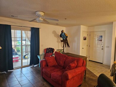 Living room with ceiling fan, a textured ceiling, 