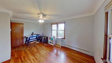 Miscellaneous room with light wood-style floors, a baseboard radiator, and ceiling fan
