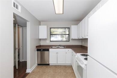 Kitchen with white appliances, dark countertops, and white cabinets