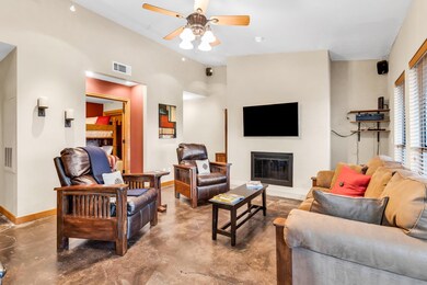 Living area with baseboards, a glass covered fire