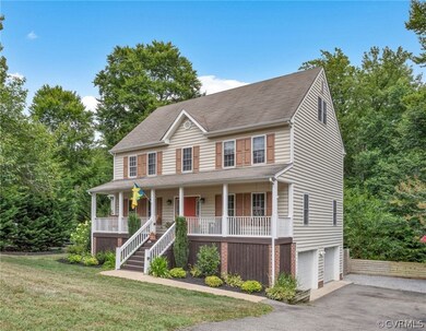 Colonial home with a porch, a garage, and a front