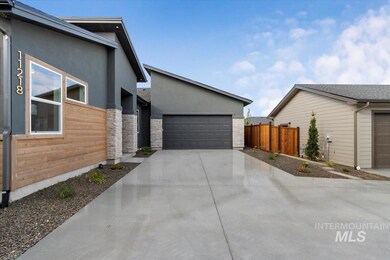 View of property exterior with stucco siding, driveway, and stone siding