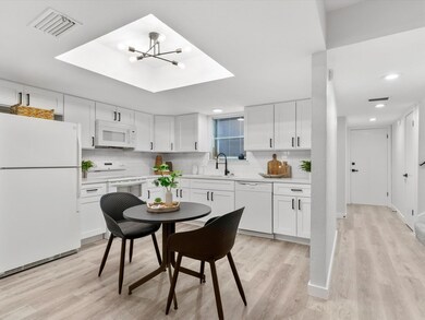 Kitchen featuring white appliances, light hardwood