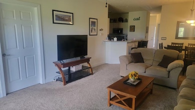 Living area with light carpet and baseboards