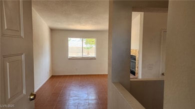 Tiled spare room featuring a tile fireplace, a tex