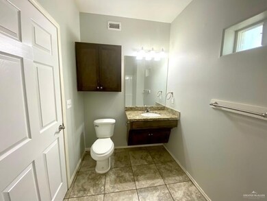 Half bathroom featuring toilet, tile patterned floors, visible vents, and baseboards
