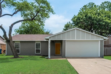 Single story home featuring concrete driveway, a front lawn, an attached garage, board and batten siding, and brick siding