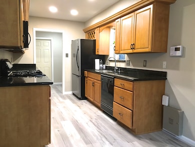 A different view of the kitchen with the adjacent utility room and garage door. Alarm pad is easily accessible as you come through the kitchen.