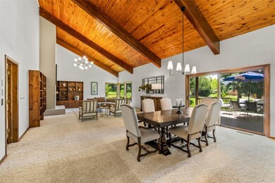 Carpeted dining area with a chandelier, high vault
