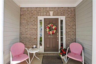 Entrance to property with covered porch and brick siding