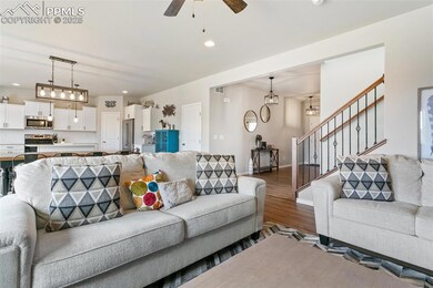 Living room with stairway, recessed lighting, baseboards, ceiling fan, and wood finished floors