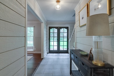 Entryway with french doors, ornamental molding, and tile patterned floors