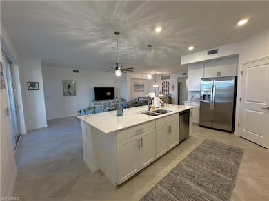 Kitchen with white cabinetry, sink, stainless stee