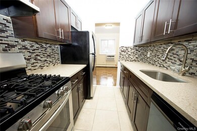 Kitchen with appliances with stainless steel finishes, dark brown cabinets, light stone countertops, and exhaust hood
