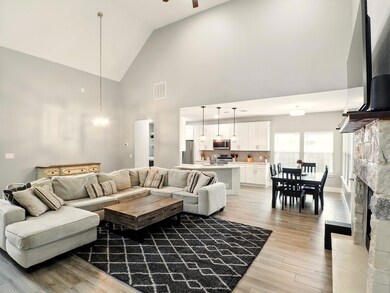 Living area with high vaulted ceiling, light wood