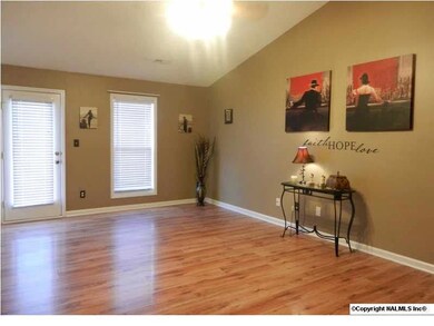 Large family room features vaulted ceilings and beautiful laminate flooring.
