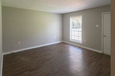 Empty room with dark hardwood / wood-style floorin