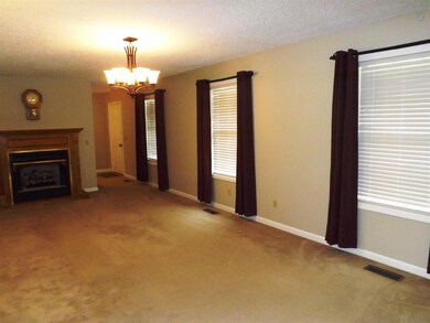 The spacious living room has three sunny windows, gas fireplace and opens to the kitchen.