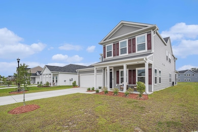 View of front facade with covered porch, concrete driveway, a front lawn, and a garage