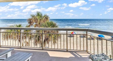 Balcony featuring a water view and a beach view