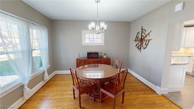 Dining space with a healthy amount of sunlight, light hardwood / wood-style floors, and a chandelier