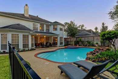 Beautiful backyard with wrought iron fence around the pool area. Notice the covered patio!