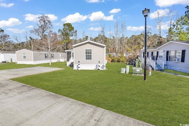 Exterior space featuring concrete driveway, a lawn