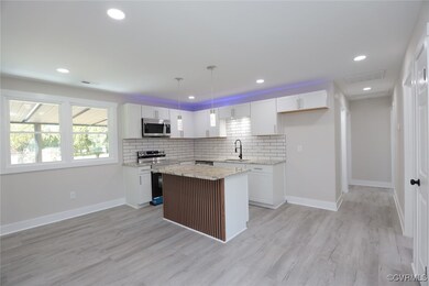Kitchen featuring a kitchen island, white cabinetr
