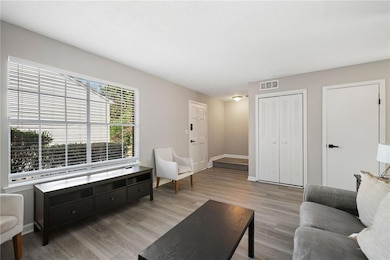 Entrance and living area, front window, front door, and the entrance to the upstairs.