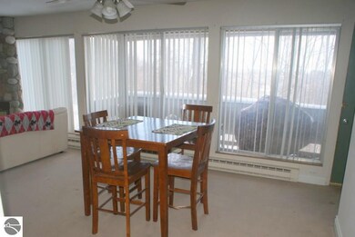 The  dining area is backlit by the wall of windows