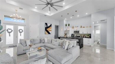 Living room featuring a raised ceiling, a towering