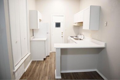 Kitchen with a peninsula, dark wood-style floors,