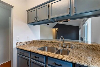 Kitchen with a sink, light stone countertops, and
