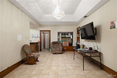 Sitting room with a tray ceiling, light tile patterned floors, and a chandelier