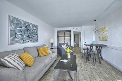 Living area with a textured wall, baseboards, and 