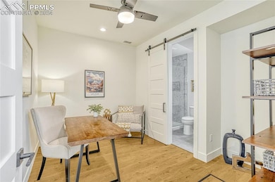 Living area with a barn door, light hardwood / woo