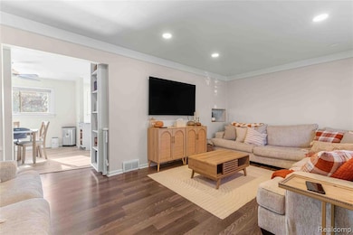 Living room featuring wood finished floors, recessed lighting, ornamental molding, and a ceiling fan