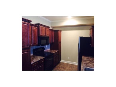 Gorgeous tile backsplash, cherry cabinets, black a