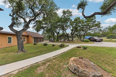 View of grassy yard with a gazebo and driveway
