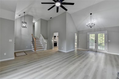 Unfurnished living room featuring high vaulted cei
