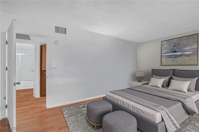 Bedroom featuring wood finished floors, a textured