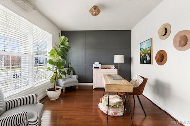 Dining room (used as office) has hardwood floor, ceiling light and craftsman detail.