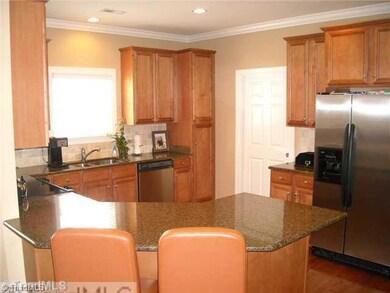 Kitchen. The door at the back of the kitchen leads to a large pantry and laundry room. Refrigerator to remain. Note the recessed lighting and crown mouldings.