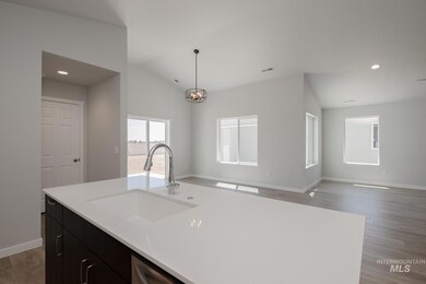 Kitchen with light wood-style flooring, recessed lighting, dark cabinetry, open floor plan, and pendant lighting
