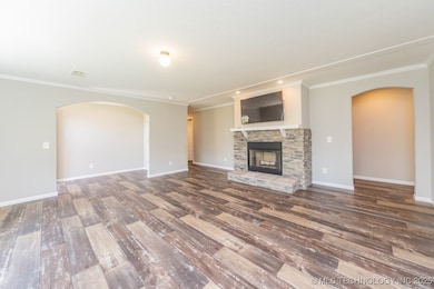 Unfurnished living room with arched walkways, wood