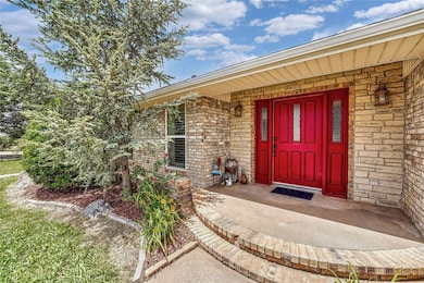 Entrance to property featuring brick siding and a porch