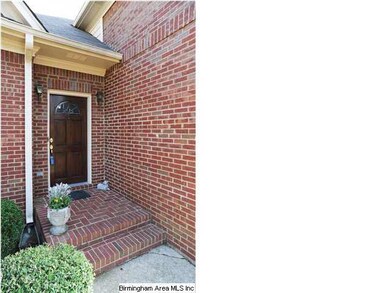 The front sidewalk winds through a planting bed an