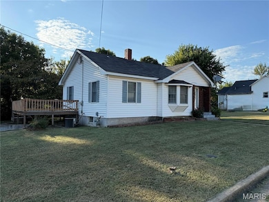 Ranch-style house featuring a front lawn, a chimney, and roof with shingles